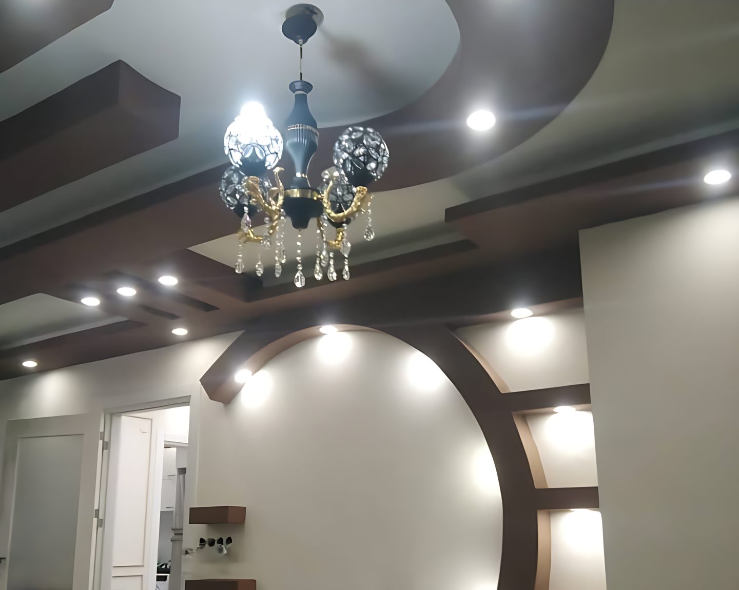 Gizli ışıklı alçıpan asma tavan, ortada kristal avize ve kemerli duvar nişi