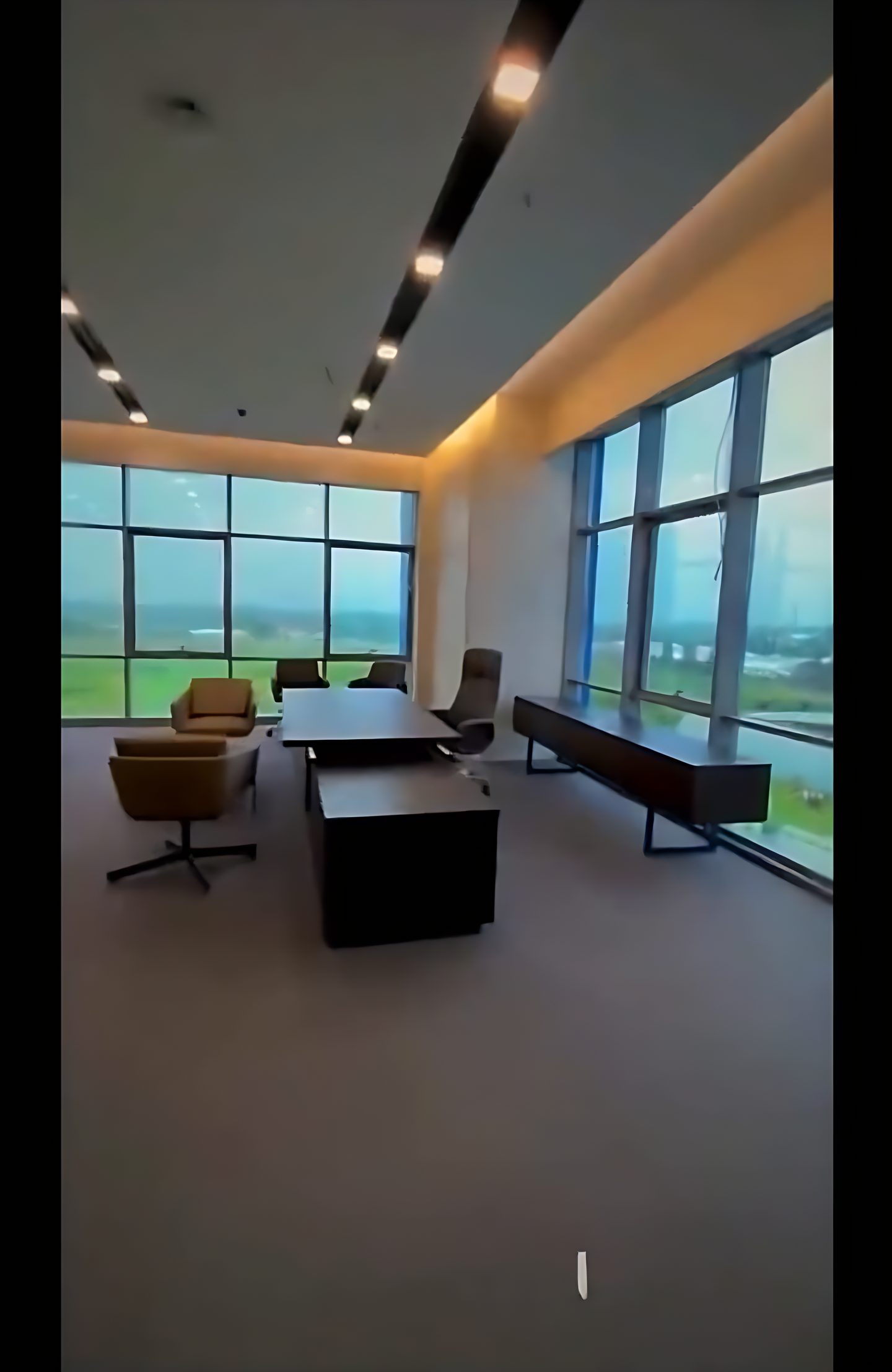 Geniş pencereli ofis, ray spotlar ve çalışma masası